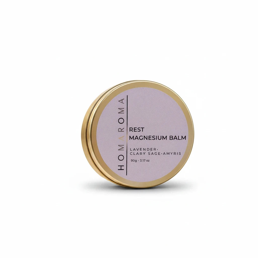 Homaroma Rest magnesium balm in a round gold tin with a lavender label featuring lavender, clary sage, and amyris.