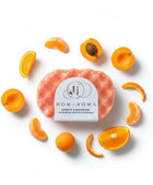 Homaroma Apricot & Mandarin exfoliating soap filled sponge with fresh apricot and mandarin slices arranged around it.