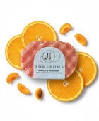 Homaroma Apricot & Mandarin exfoliating soap-filled sponge with fresh apricot slices and orange slices.