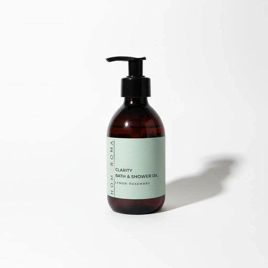Homaroma Clarity bath and shower oil in a brown glass bottle with a pump dispenser and light green label.