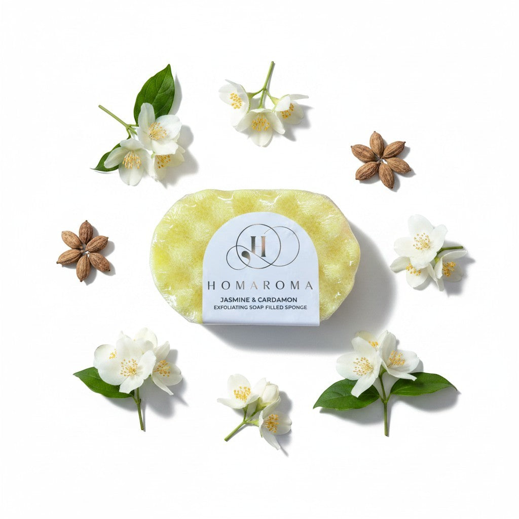 Homaroma Jasmine & Cardamom exfoliating soap filled sponge, yellow, surrounded by jasmine flowers and cardamom pods.