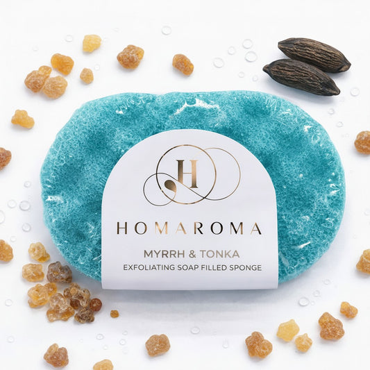 Homaroma Myrrh & Tonka exfoliating soap-filled sponge in teal blue, creating a creamy lather for cleansing and exfoliation.