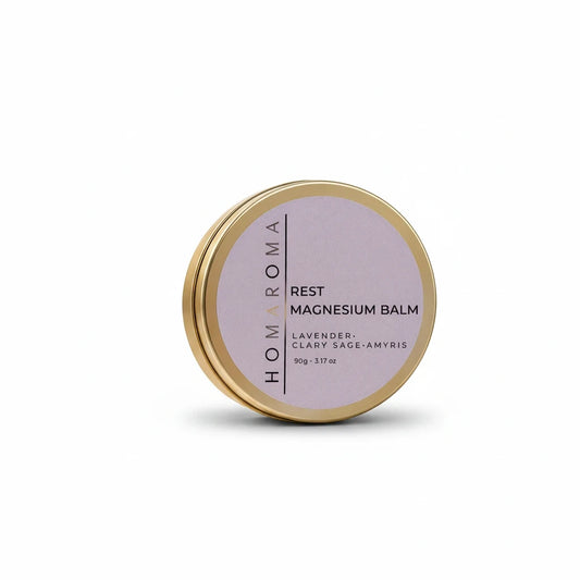 Homaroma Rest magnesium balm in a round gold tin with a lavender label featuring lavender, clary sage, and amyris.