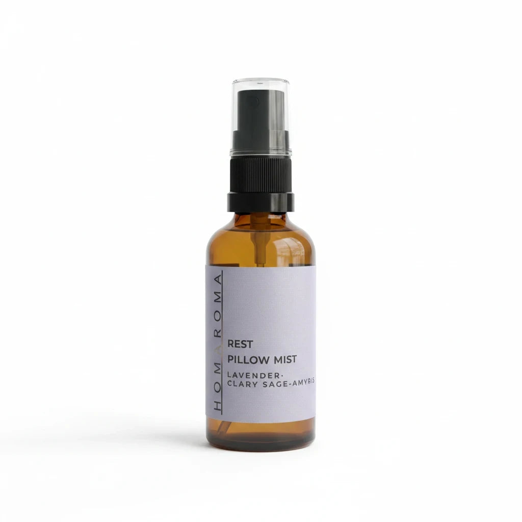Homaroma Rest pillow mist in an amber glass spray bottle with a lavender label for a calming bedtime ritual.